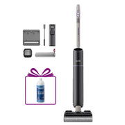 A cordless stick vacuum cleaner in dark gray and silver, shown with several accessories and a gift box containing a blue cleaning bottle on a plain white background.